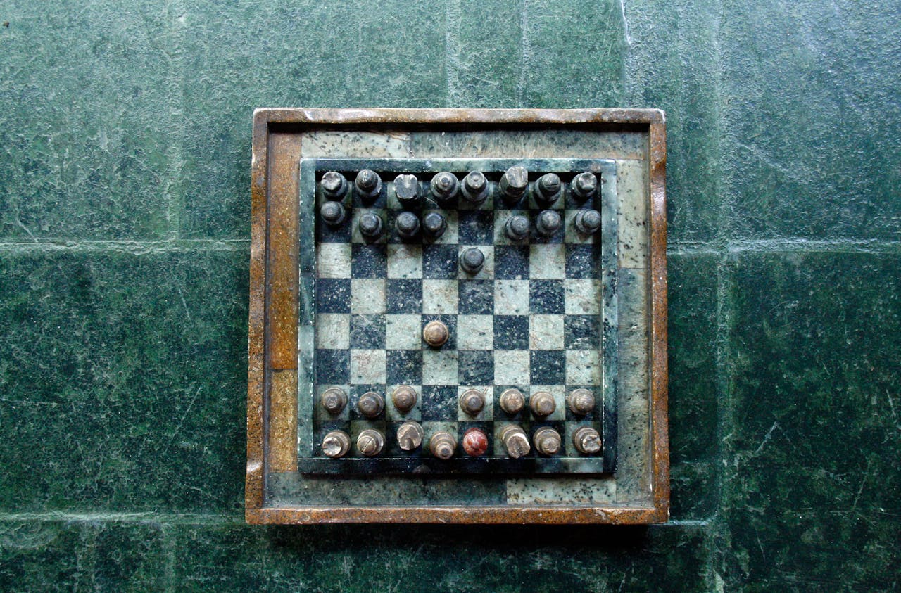 gallery-06 Top view of a vintage stone chessboard showing a strategic game position.